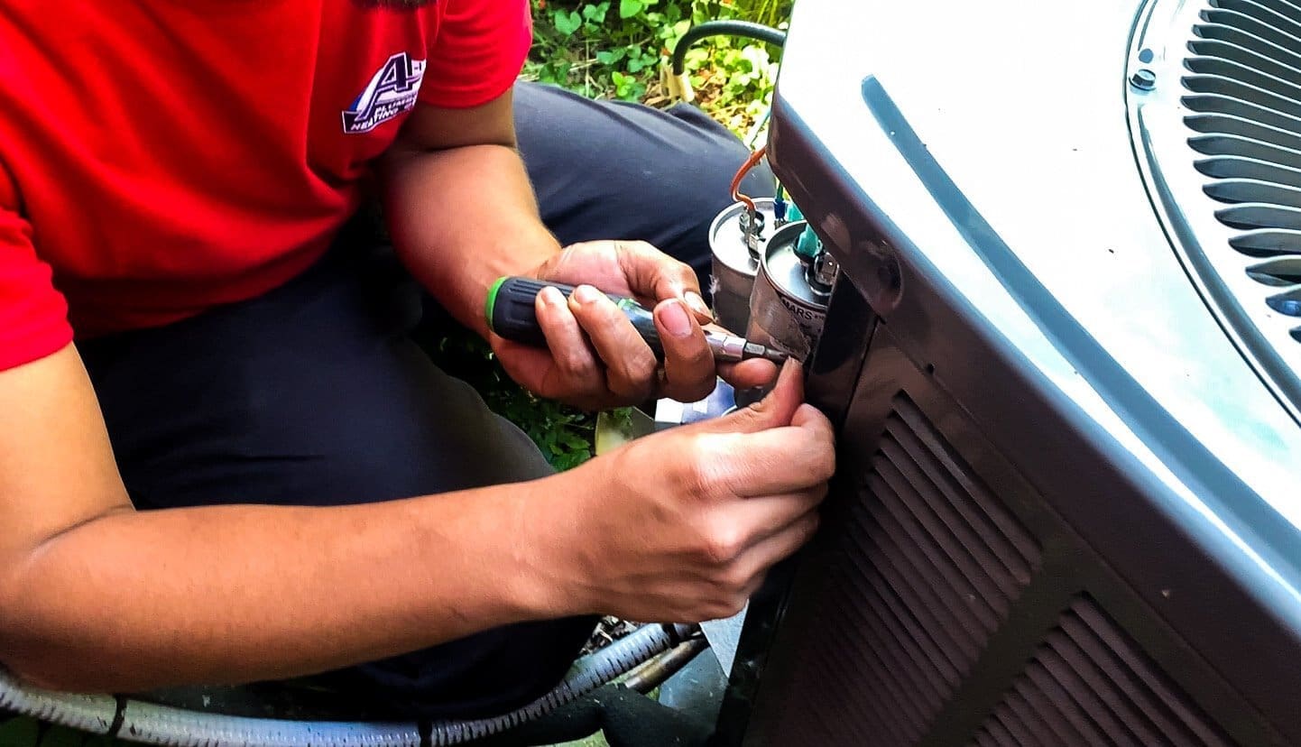 Technician repairing outdoor AC unit